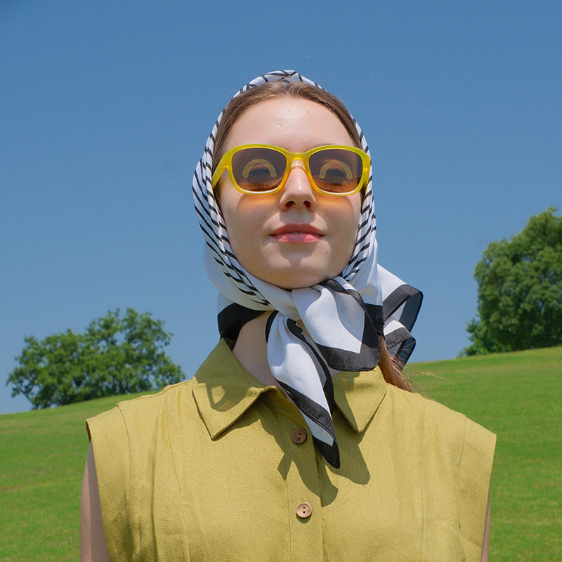 Happy child wearing SmileyWorld Sunlight Yellow kids sunglasses playing outdoors.